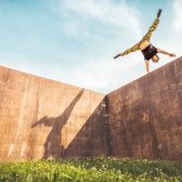 A person doing a hand flip on a wall Description automatically generated